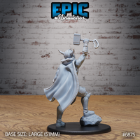 Rear view of a horned-helmed warrior with a large flowing cape with stitched border, hammer raised in one outstretched hand and axe held low, standing on a rocky sculpted crag base. Sculpt by Epic Miniatures.