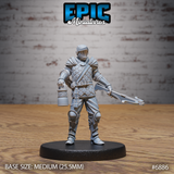 Armoured guard standing upright, holding a forked crossbow in one hand and a lantern in the other, wearing full scale mail, visor helm, greaves, and a diagonal satchel strap. Sculpt by Epic Miniatures.