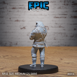 Bulldog-headed humanoid noble seen from behind, showing crossed-strap detailing across the studded doublet back, wide cinched belt, and knee-high boots. Arms folded across the chest. Sculpt by Epic Miniatures.