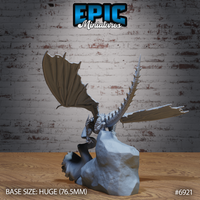 Castle Dragon Firebreath by Epic Miniatures — rear angle showing broad membranous wings with ribbed struts, armoured spine, and long sinuous neck lowered toward the rocky scenic base.