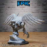 Clockwork winged creature seen from behind, feathered wings fully extended showing individual pinion detail, single segmented mechanical arm and talon visible below, hunched torso with smooth panel surfaces, perched on a jagged rocky base. Sculpt by Epic Miniatures.