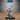 Doppelganger miniature crouched in a low combat stance, clutching a broad curved blade two-handed close to its blank, featureless face. Lithe build, spiked bracers, loose trousers, and a curved tail. Sculpt by Epic Miniatures.