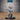 Snarling tiefling goblin miniature with spiralling ringed horns, bat ears, clawed hands raised mid-gesture, shaggy fur legs and a long lion tail with tufted tip. Sculpt by Epic Miniatures.