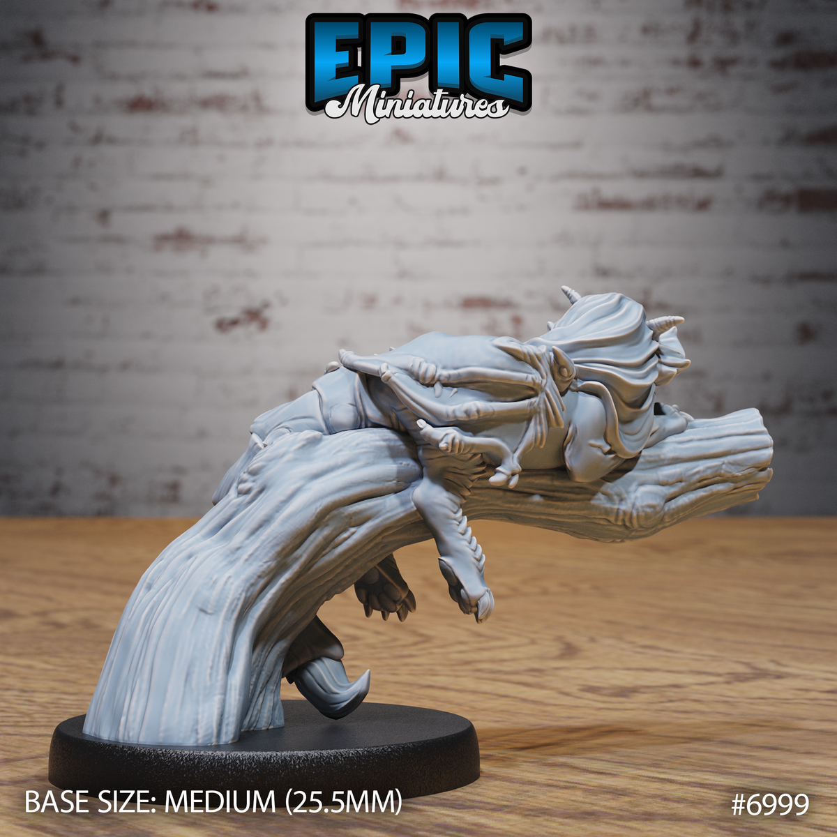 Baby manticore draped along a curved log, open-mouthed lower head visible beneath, barbed tail prominent, small horns and robed back detail shown. Sculpt by Epic Miniatures.