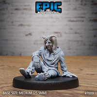 Tiefling figure seated on the ground, barefoot, one knee raised, wearing loose tattered robes with crude stitching and a circular chest scar. Long dishevelled hair, weary expression. Sculpt by Epic Miniatures.