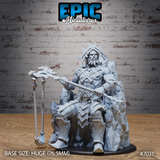 Muscular stone giant seated on a jagged rock throne, holding an ornate angular staff across his lap and a braided rope flail in his other hand, wearing geometric plate armour and a crossed-spar crown. Sculpt by Epic Miniatures.