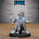 Stocky dwarf king facing forward, raising an ornate staff in his right hand and extending his open left hand, wearing layered robes, a belted tunic, and a runic angular crown. Two long braided plaits hang from his beard. Sculpt by Epic Miniatures.