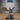 Bat folk wizard miniature crouching with one clawed hand raised palm-forward and the other gripping a twisted arcane staff, wearing a wide-brimmed hat and long coat with vials, broad leathery wings spread wide. Sculpt by Epic Miniatures.