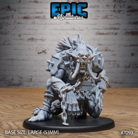 Massive crouching troll miniature with tusked open jaw and wild bone-spine mane, heavy iron chains hanging from its armoured torso, wearing riveted metal pauldrons, mounted on a large oval base. Sculpt by Epic Miniatures.
