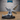 Winged fey male figure seated on a decorative base, one leg extended, holding a slender dagger loosely in one hand. Four large moth-like wings spread wide. Sculpt by Epic Miniatures.