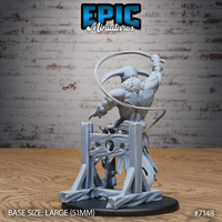 Heavily muscled masked giant figure seen from behind, whip looping dramatically overhead, scarred back exposed, rope belt and tattered robes visible, atop a detailed timber scaffold base with iron ring fastenings. Sculpt by Epic Miniatures.