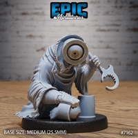 Crouching robed creature with a single large eye set in an iron-rimmed socket, gripping a hooked serrated blade, beside a small cylindrical object. Sculpt by Epic Miniatures.