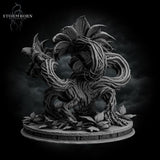 Three-quarter rear digital render of the Hydra Bloom miniature in a dynamic twisting variant — vines coiling tightly around the body with a single large lily-like bloom crowning the top, scattered leaf litter on the round scenic base, unpainted grey resin
