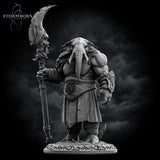 Front view of an unpainted grey resin loxodon miniature holding a large runic crescent scythe, wearing layered robes with an engraved belt medallion and ornate pauldron, standing on a rune-inscribed scenic base