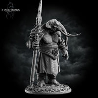 Three-quarter front view of the unpainted grey resin loxodon miniature with head bowed, gripping the ornate staff weapon with both hands, showing the full detail of the robes, medallion belt piece, and carved base