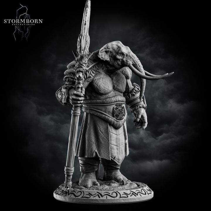 Three-quarter front view of the unpainted grey resin loxodon miniature with head bowed, gripping the ornate staff weapon with both hands, showing the full detail of the robes, medallion belt piece, and carved base