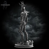 Digital render of an unpainted grey Treant miniature from Stormborn Collectibles — three-quarter rear view revealing bark-wrapped limbs, protruding branch spurs along the spine, and a rubble-strewn scenic base