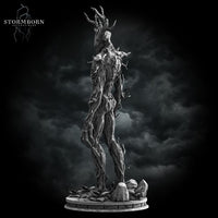Digital render of an unpainted grey Treant miniature from Stormborn Collectibles — three-quarter rear view revealing bark-wrapped limbs, protruding branch spurs along the spine, and a rubble-strewn scenic base