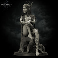 Grey resin digital render of Eva the Dryad miniature, front view — a seated female fey figure with an antler and oak leaf crown, long flowing hair, leaf-wrapped arms and calves, resting against a gnarled tree trunk with a climbing rose at her feet, on a textured round base