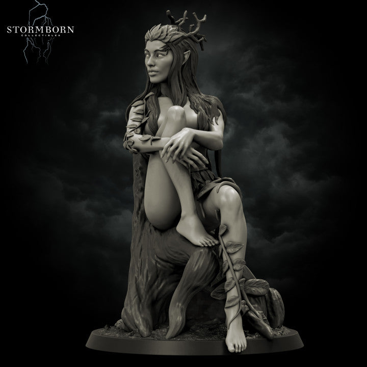 Grey resin digital render of Eva the Dryad miniature, front view — a seated female fey figure with an antler and oak leaf crown, long flowing hair, leaf-wrapped arms and calves, resting against a gnarled tree trunk with a climbing rose at her feet, on a textured round base
