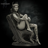 Grey resin digital render of Eva the Dryad miniature, three-quarter front view — seated in a carved tree-throne chair with broad armrests, antler crown, leaf-draped clothing, knees drawn up, one foot extended with a rose vine winding up the leg
