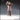 Front-facing digital render of Researcher 01 by Novaminis — an unpainted 32mm resin miniature of a stout bald man in a long buttoned lab coat, arms raised holding a rounded flask up to his face as if examining its contents