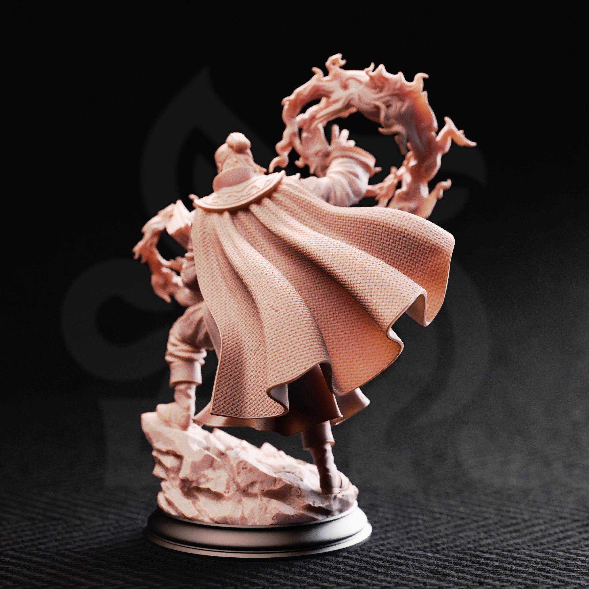 Photograph of the Aaron Drafthold Wandering Mage miniature from the rear, unpainted, showing the finely textured woven cloak billowing outward, runed shoulder clasp, and the swirling fire effect extending behind him over the rocky base