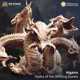 Digital render of Algaira, the Hydra of the Shifting Dunes miniature by DM Stash — five-headed hydra with coiled scaly body, multiple open-mouthed heads with curved fangs and horn crests, shown in sandy bone tones against a dramatic mountain backdrop