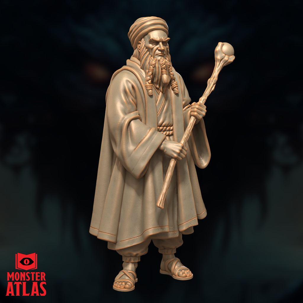 Elderly bearded wizard in flowing robes and turban, clutching a gnarled staff with an orb finial, sandalled feet visible beneath wide hems. Weathered, scowling face with deep-set eyes. Sculpt by Monster Atlas.
