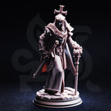 Front-view photograph of the unpainted Arch Paladin Tyrius III miniature against a dark background, showing the full detail of his chainmail robes, decorative stole, spiked pauldrons, cross headpiece, and ornate reliquary mace staff. The rubble base is clearly visible.