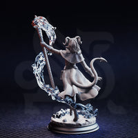 Unpainted grey resin miniature of Aria the Faithful tiefling sorceress, rear three-quarter view — shows barbed tail, back of layered coat with fabric texture, curling horns, and the full sweep of the spectral energy staff wrapping around the figure