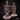 Two BBQ spit campfire terrain pieces by Mia Kay M3DM side by side — tall posts with crossbars hung with chains, hooks, sacks, and bones on rocky rubble bases. One base has sculpted flames.