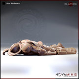 Digital render of the Dead Watchman 01 miniature by Novaminis — a male human guard in studded leather brigandine lying face-down, arms outstretched, round riveted shield beside him, viewed from a low front angle showing full armour and boot detail