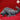 Grey unpainted resin digital render of a basilisk miniature by Yasashii Kyojin Studio, shown in profile view with spined dorsal ridge running from neck to curled tail, broad armoured body, and four clawed feet, against a red background