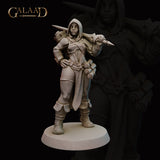 Front view of an unpainted grey resin miniature of a hooded female human battlemage, standing with one hand on her hip and a dagger levelled in her right hand, with a scroll or bolt quiver rising behind her shoulder and layered split coat with knee armour — 32mm scale by Galaad Miniatures