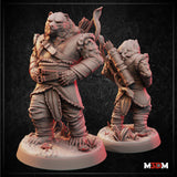 Two unpainted grey resin Bearfolk Ranger miniatures shown front and back — a large bear-folk figure in layered leather armour with buckled chest strapping, carrying a bow and arrow quiver, standing on a detailed naturalistic base with small plants and crystals