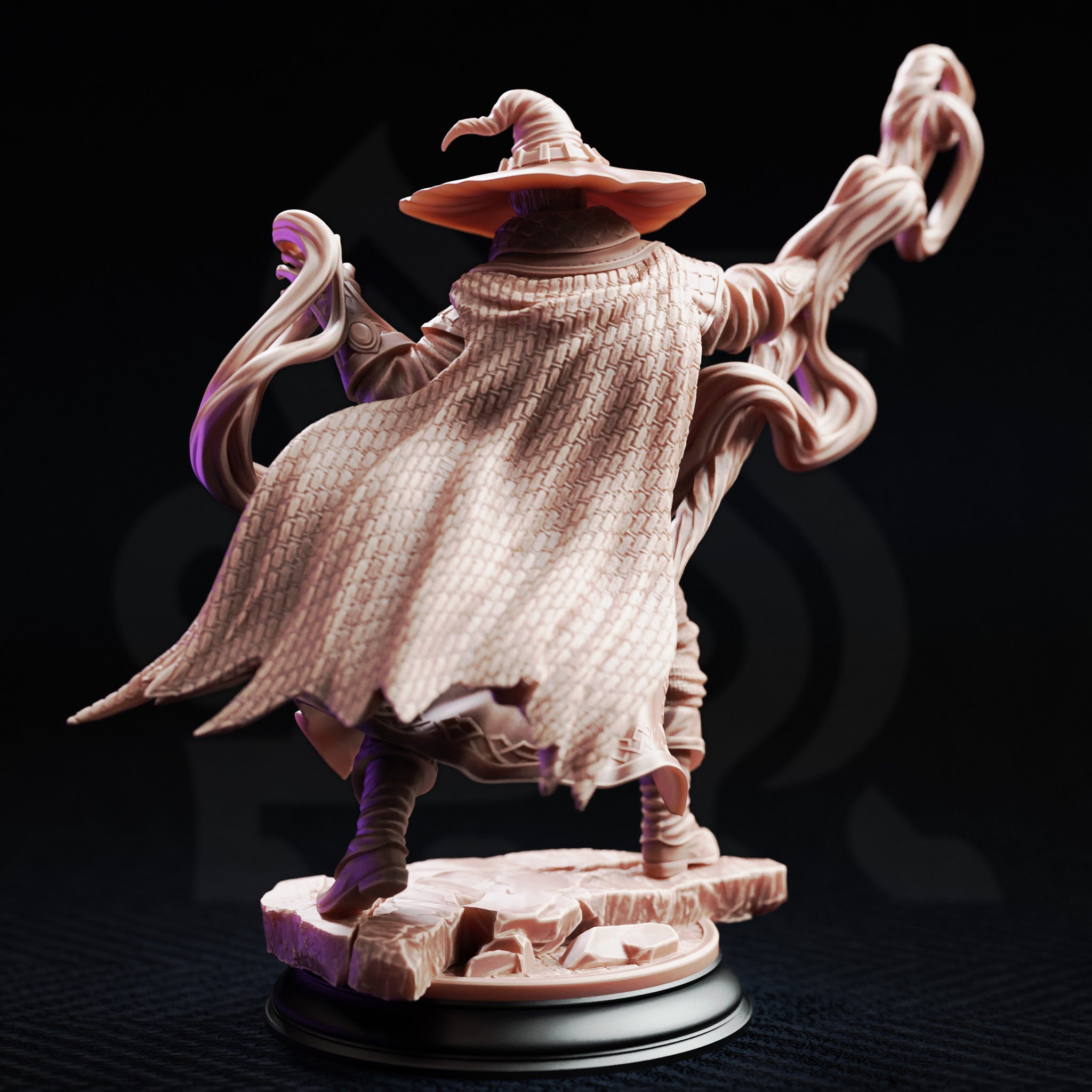 Rear view of Big Hat Harrison miniature showing the finely textured woven pattern of his swept cape, bound leg wraps, and the two arcing energy tendrils extending to either side. The sculpt sits on a broken flagstone base mounted on a black display plinth. Unpainted grey resin.