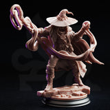 Front-facing view of Big Hat Harrison on a black display plinth, showing the full detail of his arcane medallion, belted coat, layered pouches, fleur-de-lis cape clasp, and the twin spiralling energy tendrils extending outward from both hands. Unpainted grey resin, 32mm scale.