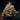 Front three-quarter view of the Brackish Trudge unpainted resin miniature — a massive low-slung beast with a tusked face, splayed clawed forelimbs, and a back densely covered in tumorous growths, fungal masses, and trailing tendrils. Monster Atlas sculpt.