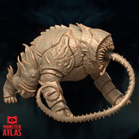 Unpainted resin render of the Canoloth miniature by Monster Atlas, viewed from the right side — displaying the overlapping armoured carapace plates, flame-like chitin crests along the haunches, and the segmented barbed tongue extending forward