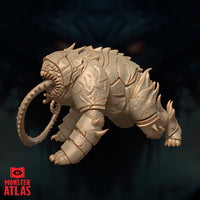 Unpainted resin render of the Canoloth miniature by Monster Atlas, viewed from the rear-left — revealing the heavily textured underbelly, segmented armour plating, a secondary circular toothed mouth near the rear haunch, and the full sweep of the spined tongue