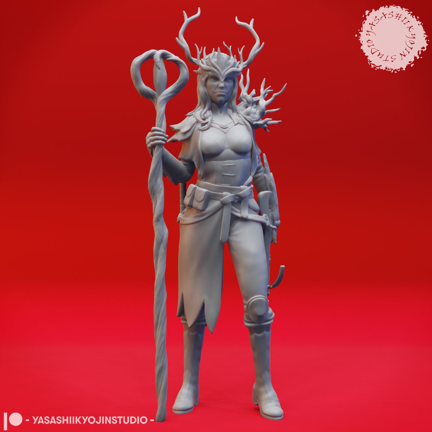 Front view of an unpainted grey resin druid miniature by Yasashii Kyojin Studio, showing branching antlers, a twisted looped staff held in her left hand, leather belt with satchel and blade, and a draped cloak — digital render on red background
