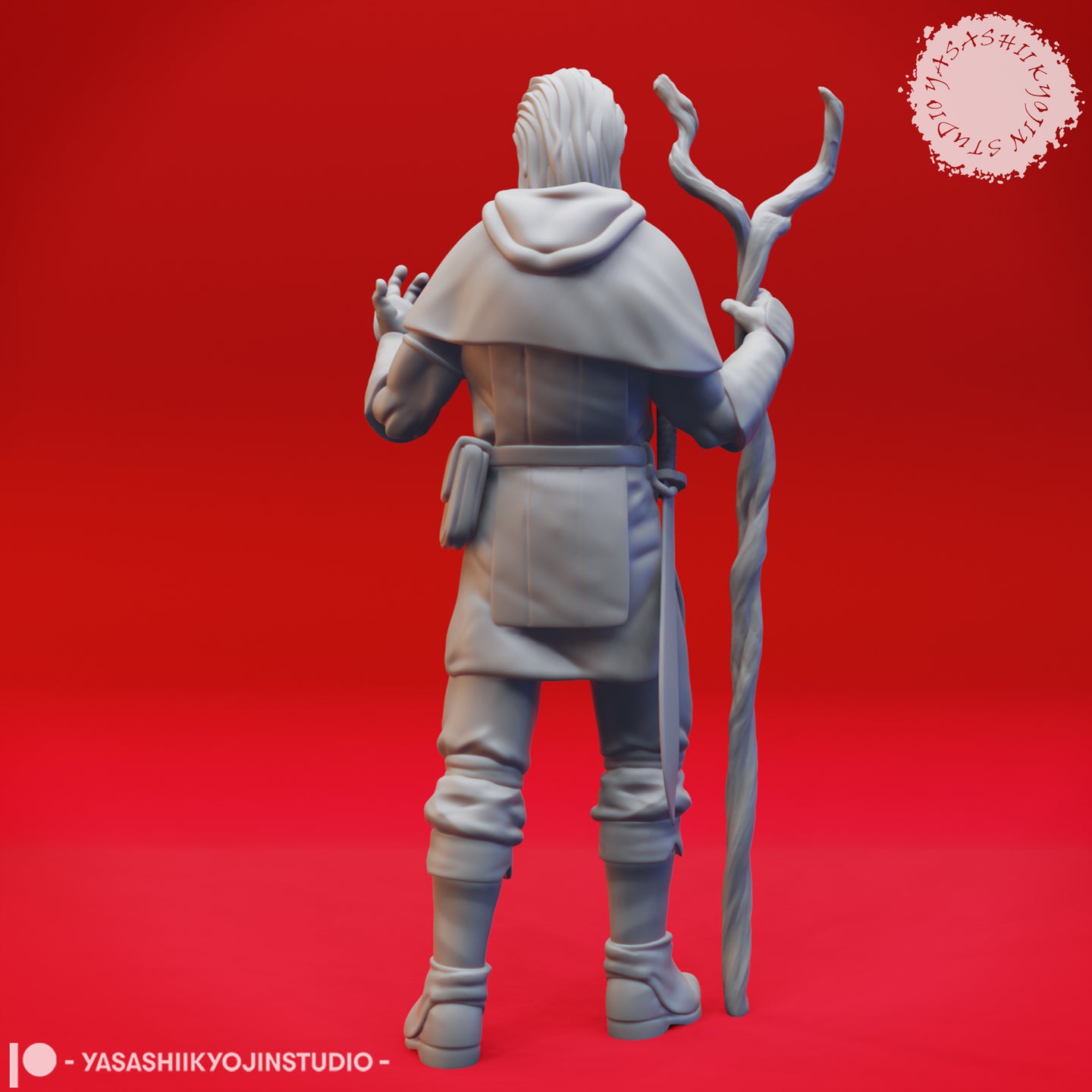 Rear view of the same unpainted grey resin male druid miniature showing the detailed hood, flowing capelet, belt pouches and the gnarled staff held in his left hand with his right hand raised behind him