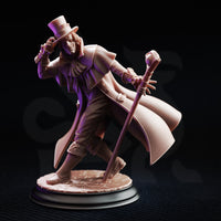 Front three-quarter view of the unpainted grey resin Cobalt Fairfax miniature on a black background, clearly showing the scarred and cracked facial detail on the left side of the face, the layered cape, dynamic striding pose, and the full length of the orb-headed staff
