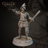 Front view of an unpainted grey resin Conquistador miniature at 32mm scale, sculpted by Galaad Miniatures. The figure wears layered leather armour with double buckled belts and faulds, and a broad-brimmed feathered hat. He holds a short sword in his right hand and extends his left arm outward in a commanding gesture. His bearded face bears a stern, authoritative expression. He stands on a round cobblestone base.