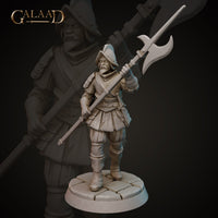 Front view of an unpainted grey resin 3D printed miniature of a stocky bearded soldier in padded armour and a wide-brimmed morion helmet, striding forward while raising a long halberd. Sculpted by Galaad Miniatures at 32mm scale on a cobblestone base.