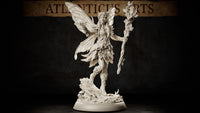 Winged fairy miniature standing on a root-and-mushroom base, holding a leafy staff aloft, wearing a leaf skirt and bodice, long braided hair, large veined wings spread wide. Sculpt by Atlanticus Arts.