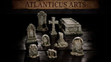 Nine weathered resin graveyard scatter pieces arranged together: two large ornate headstones with Gothic arched niches, a stone cross, a sarcophagus with carved lid, a broken column stump, and three smaller eroded grave markers. Sculpts by Atlanticus Arts.
