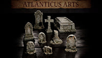 Nine weathered resin graveyard scatter pieces arranged together: two large ornate headstones with Gothic arched niches, a stone cross, a sarcophagus with carved lid, a broken column stump, and three smaller eroded grave markers. Sculpts by Atlanticus Arts.