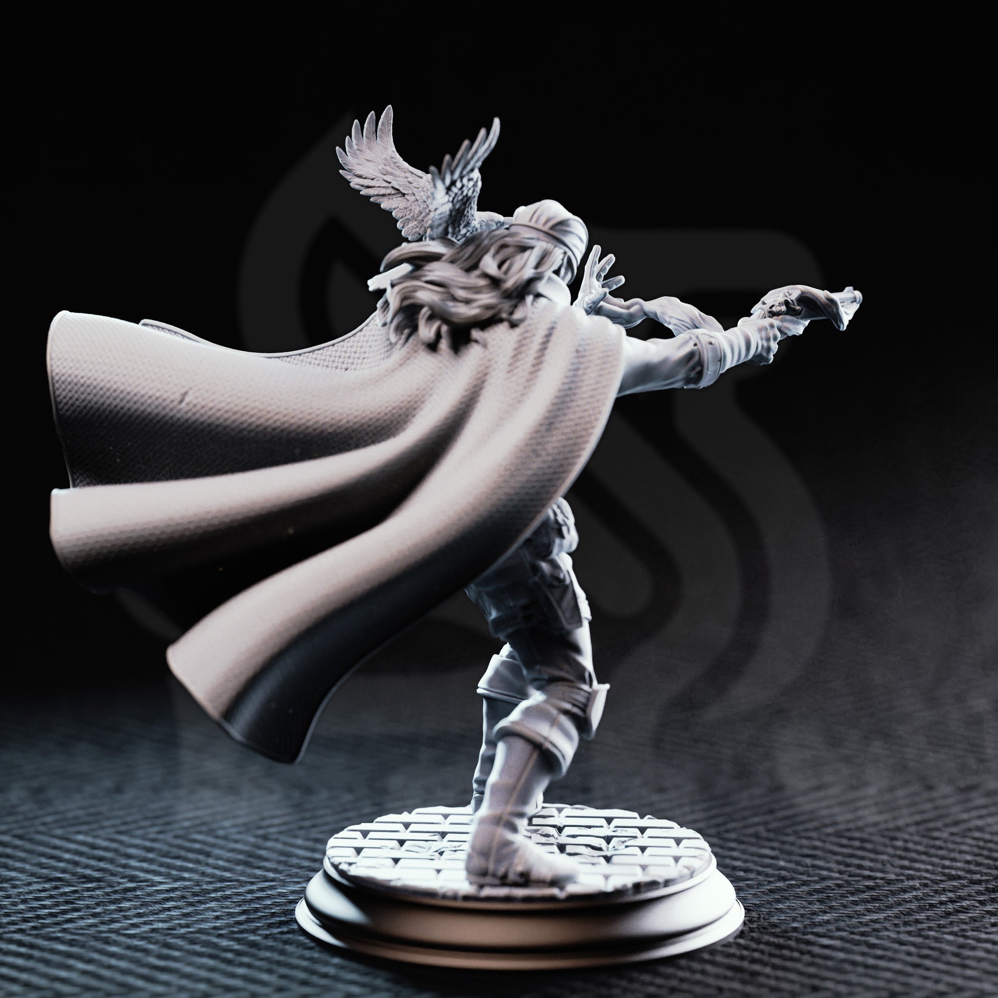Photograph of unpainted grey resin Crow Eyes Blind Gunslinger miniature — rear three-quarter view showing long hair beneath the blindfold wrap, the textured woven lining of the billowing cape, crow familiar visible from behind with wings spread, and the cobblestone round base